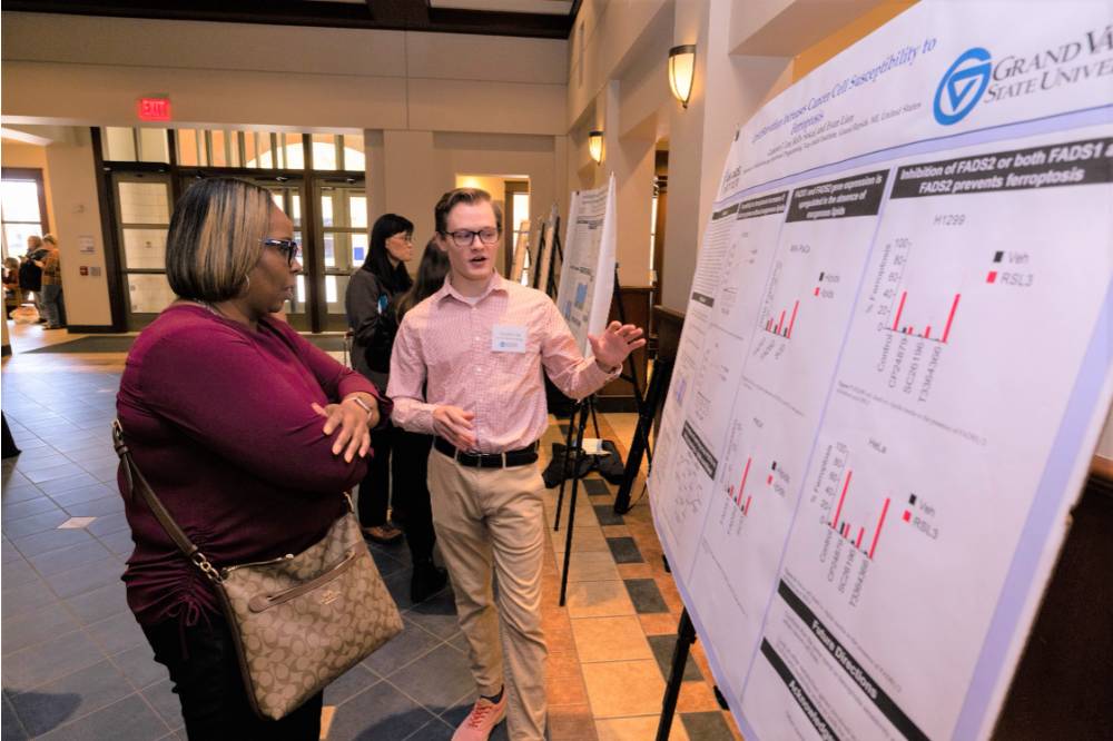 Cameron (right) presenting their poster at the Graduate Showcase.